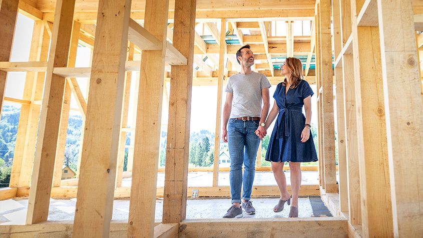 Smiling couple walking through new home construction