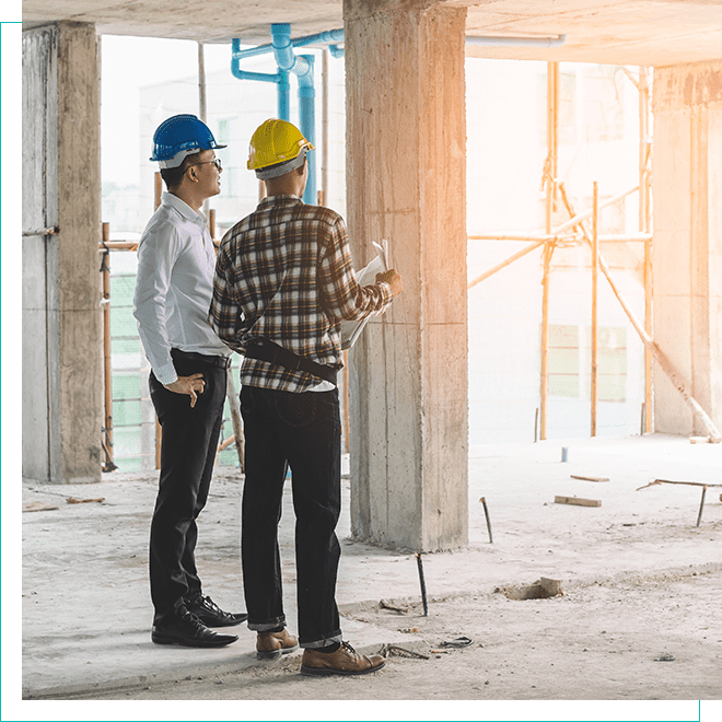 Real Estate Development: Professionals Overseeing Construction Progress Two construction professionals in hard hats discussing plans on a building site, representing active development in real estate.